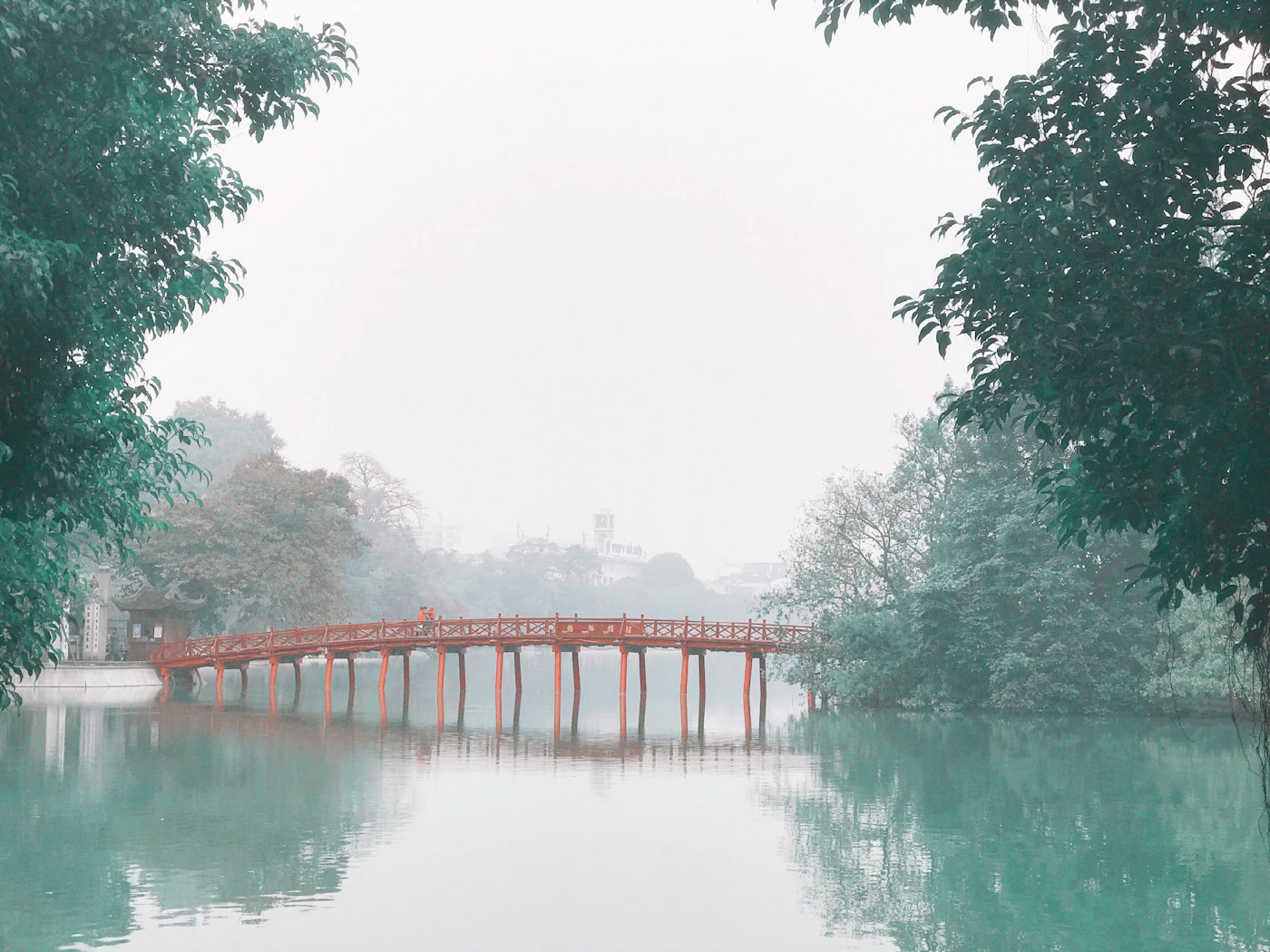 The red Huc Bridge on Hoan Kiem Lake in the morning mist